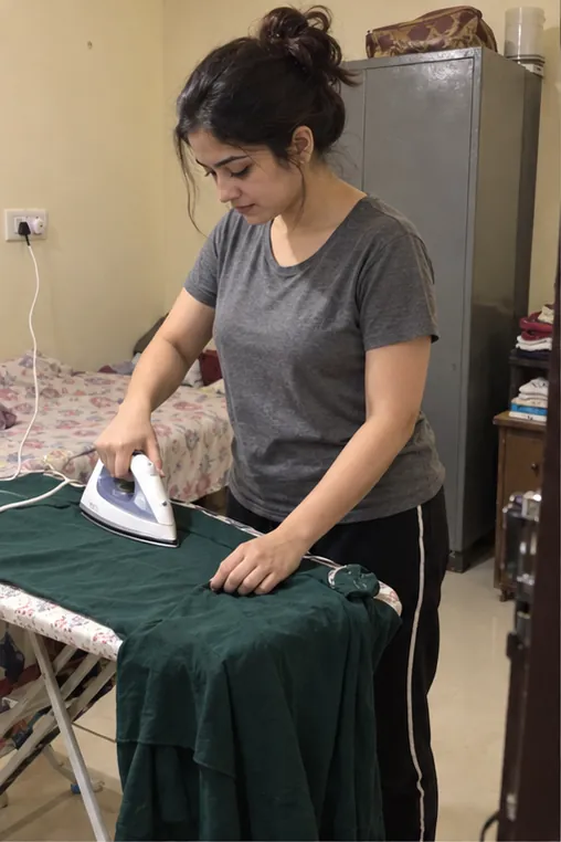 Bangalore call girl ironing her green dress before a booking